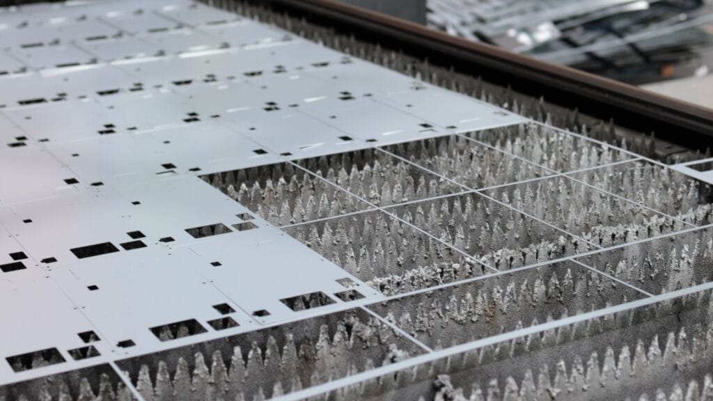 laser cut steel sheet nested parts on cutting bed