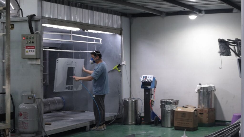 powder coating spray booth worker spraying alternate