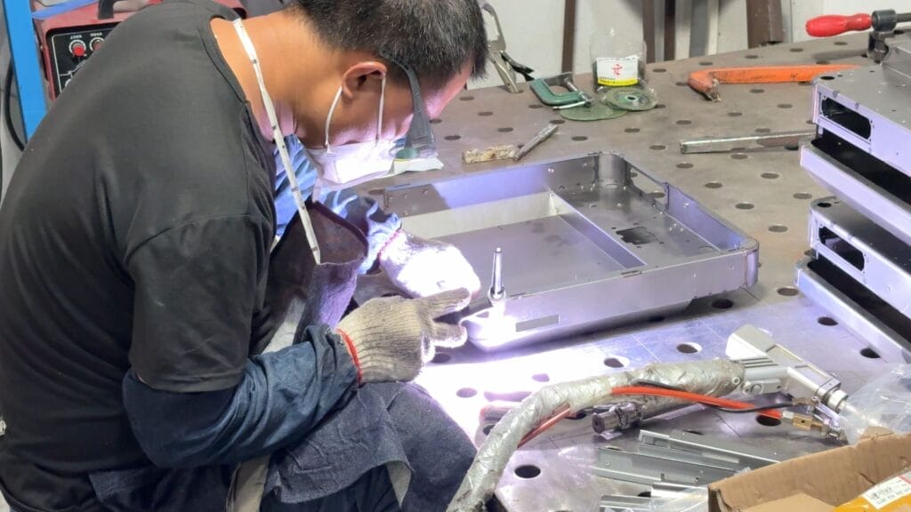 tig welding stainless steel enclosure tray worker closeup